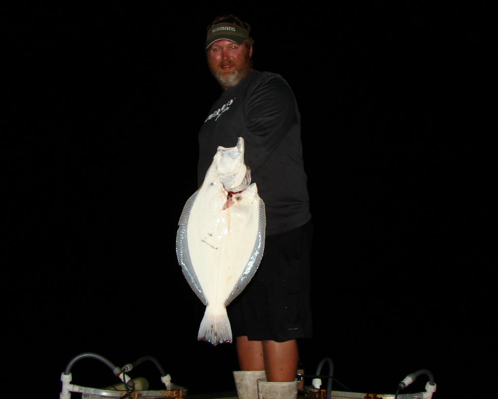 Captain Allen Jernigan with a flounder he just gigged on the coast of North Carolina.